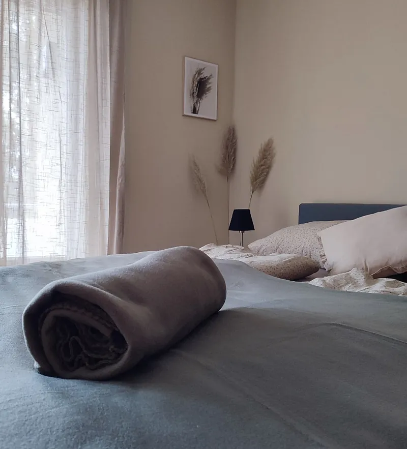 Doppelbett mit Pampasgras und warmen Naturtönen